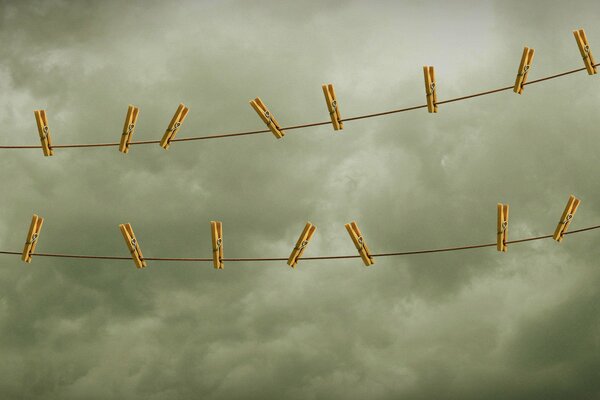 Wooden clothespins on ropes against the dark sky