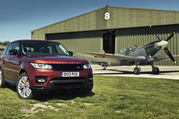 El Range rover rojo se encuentra en el hangar y el avión