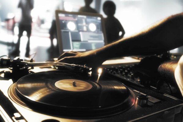 Un DJ hace música en un disco en un plato giratorio