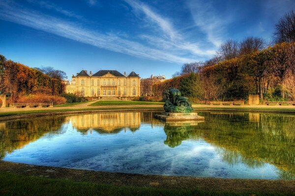 A house in Paris with a fountain and a pond