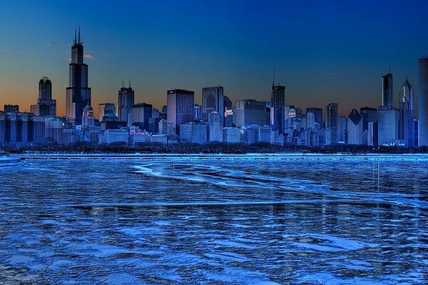 Panorama of the evening city on the river bank