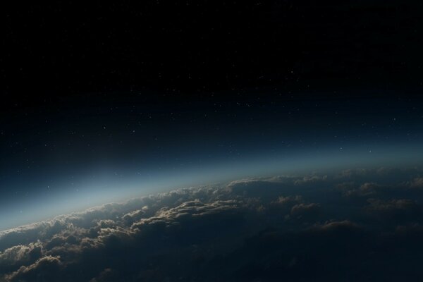 A semicircle of atmosphere with clouds on the background of the starry sky