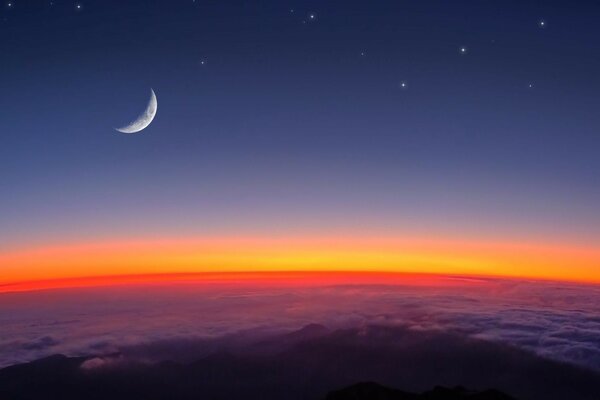 Imagen de la Luna y las estrellas sobre las nubes