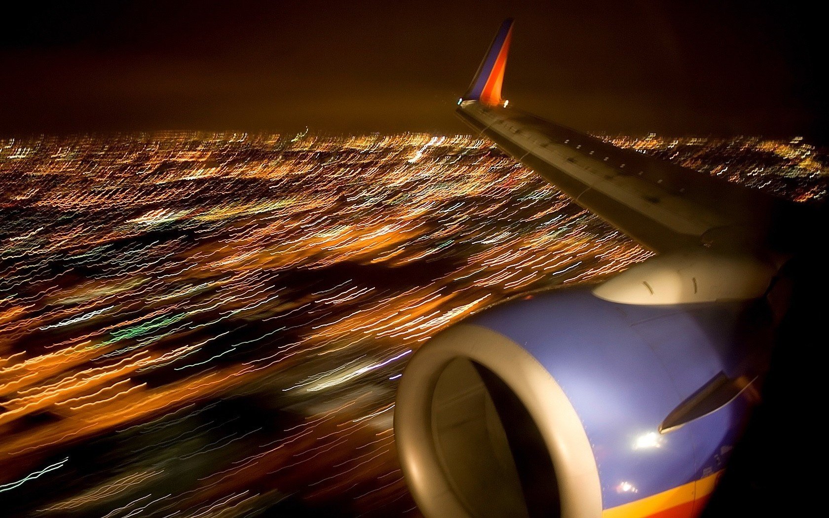 blurred view the wing of the plane flight in the night turbine city lights aircraft air air transport