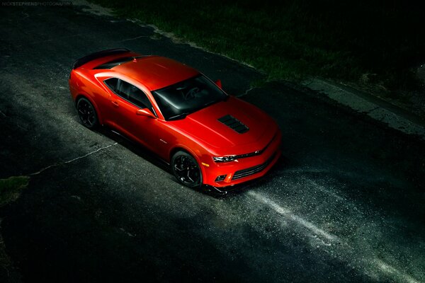 Red chevrolet camaro on a dark road