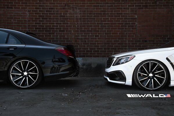 Deux Mercedes sur fond de mur de briques