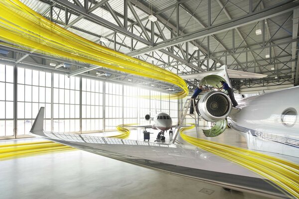 Ein gelbes Flugzeug, das in Bänder gehüllt ist, steht im Hangar