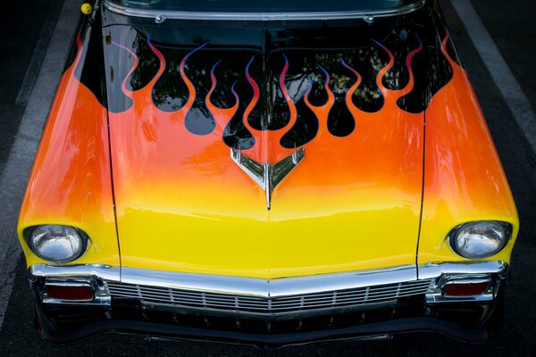 Yellow hood of a classic black Chevrolet