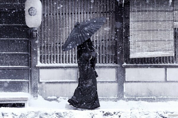 Scrivania Giapponese cammina sotto la neve con un ombrello