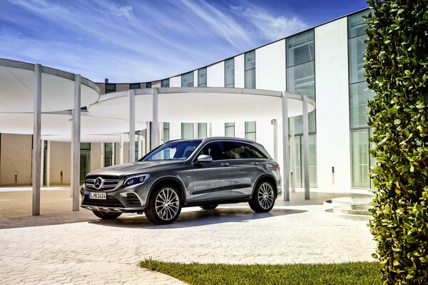 Black Mercedes under the canopy of a tall building