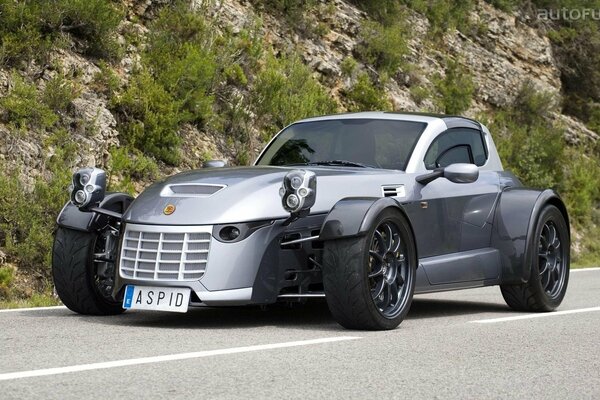 Gray passenger car in the mountains on the road