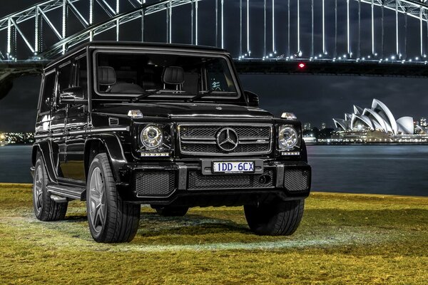 Coche negro contra el océano y la ciudad