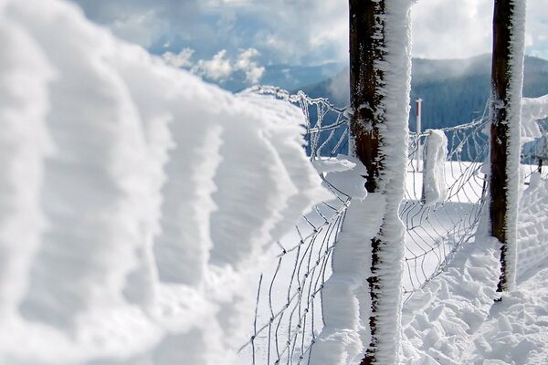 Clôture de neige sur fond de montagnes d hiver