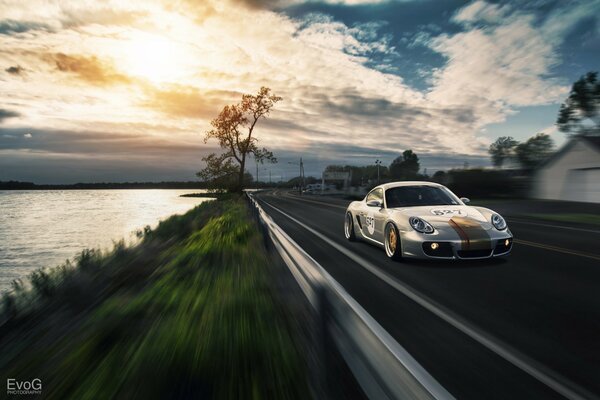 Porshe in den Sonnenuntergang, rast entlang der Strecke am Meer entlang