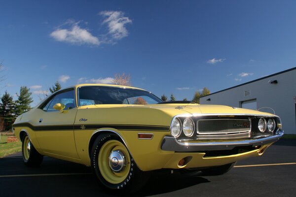 Coche retro amarillo se encuentra en la carretera al lado del garaje