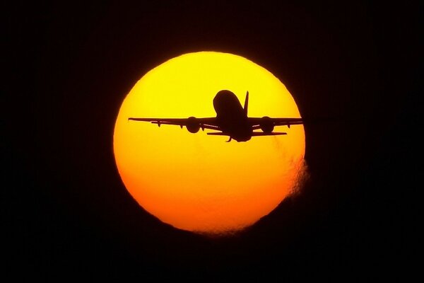 Avion volant sur fond de soleil