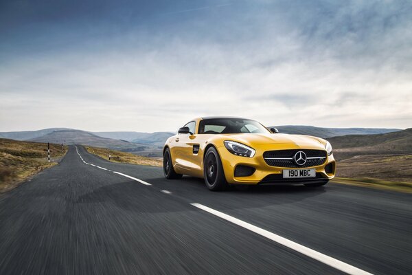 Mercedes de color amarillo que viaja por el camino