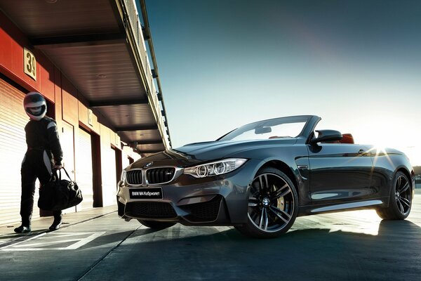 Dark grey BMW convertible with racer