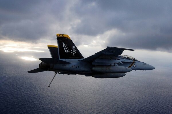 Military fighter in the air over the sea