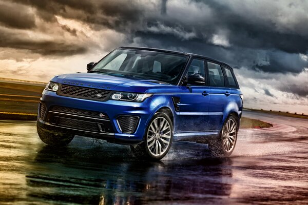 Blue Range Rover guida su una strada bagnata