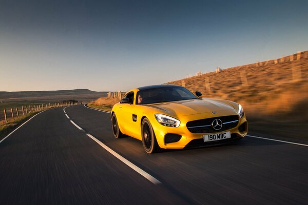 Yellow Mercedes 2015 rushes along an asphalt road