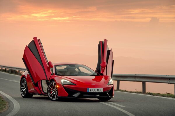 Carta da parati supercar mclaren 570s con porte aperte durante il tramonto