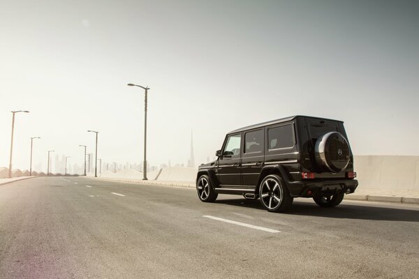 Mercedes-benz negro en una carretera brumosa