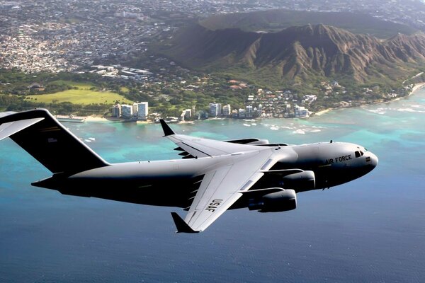 A military plane flies over a quiet resort. In