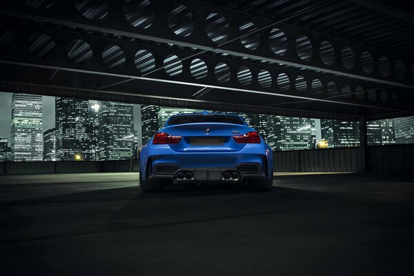 Vista de la ciudad nocturna, rascacielos y BMW azul