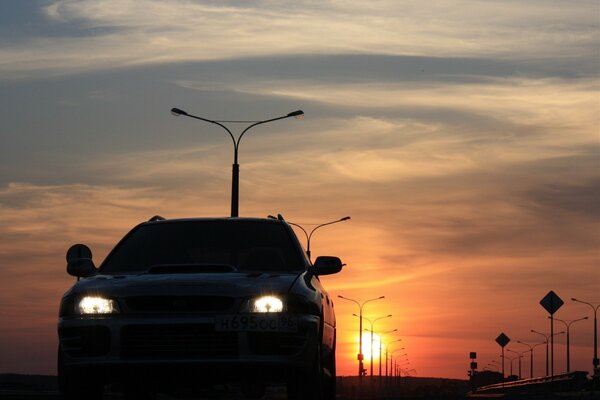 Phares d une voiture au coucher du soleil