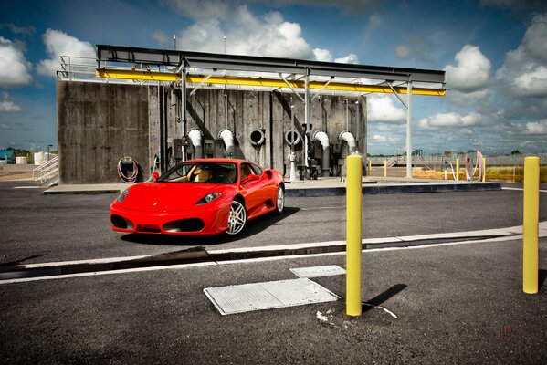 Ferrari F430 rouge à la structure avec des tuyaux