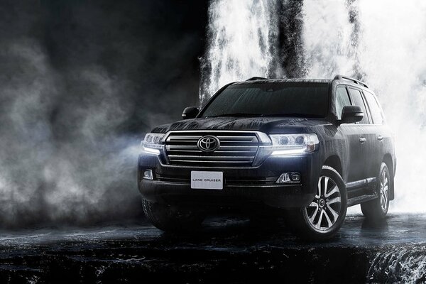 Toyota Land Cruiser negro en una cascada en una neblina