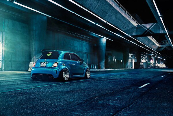 Matt blue Fiat Abarth f132 on the background of gray city roads