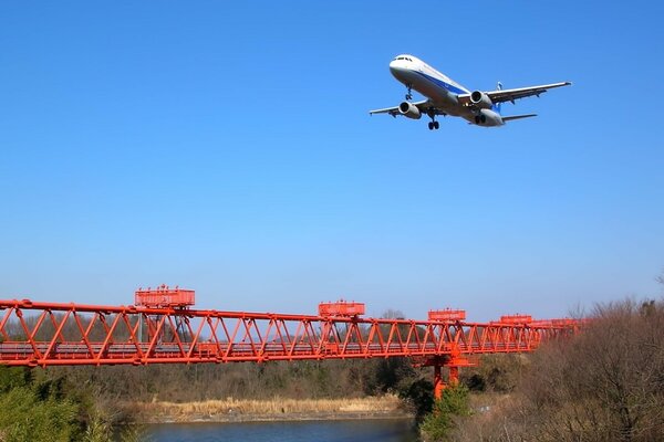 Avion de passagers volant au-dessus du pont rouge