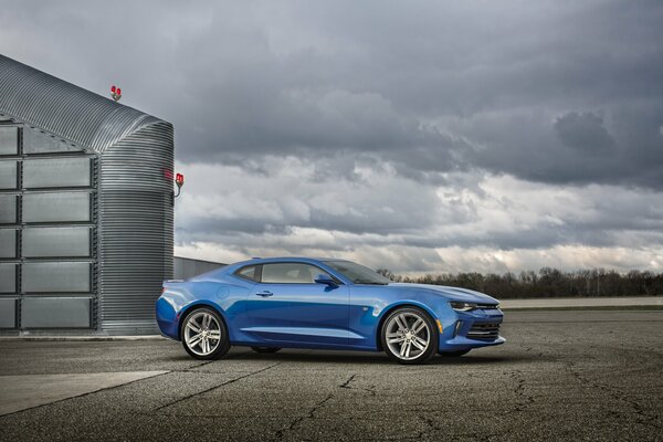 Azul chevrolet Camaro RS 2015 en medio de un cielo tormentoso