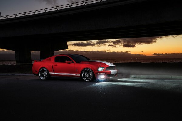 Ford rojo, puesta de sol luces delanteras brillan