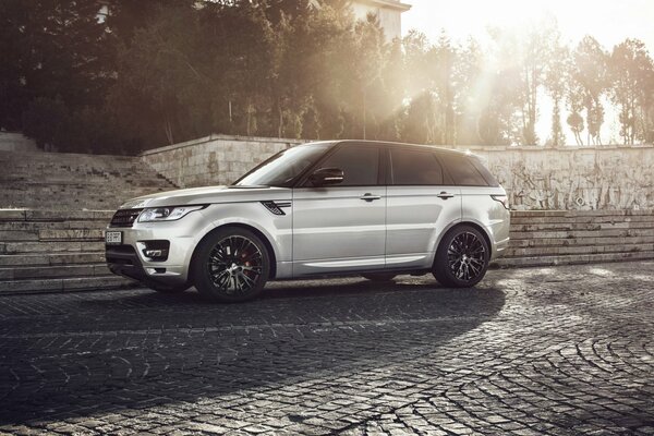 Silver range rover on a stone road