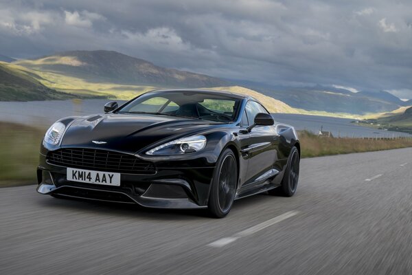 Aston Martin de color oscuro en la carretera