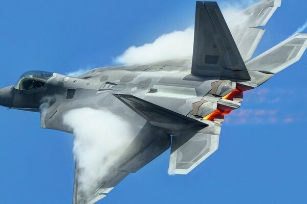 Military fighter f-22 during overcoming the sound barrier in flight