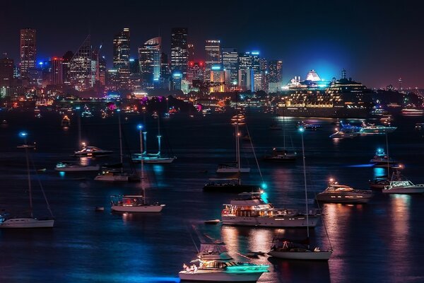 View of the night city from the river bank where there are many yachts