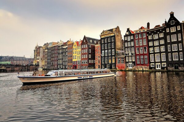 A motor ship on the background of a river and high-rise buildings