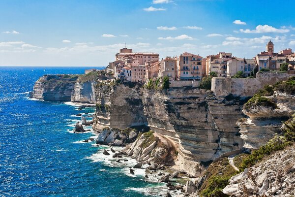 Mer bleue et maisons sur les rochers