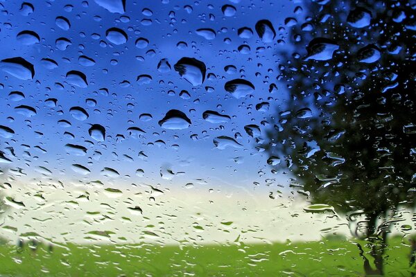 Blue sky on a background of glass in drops