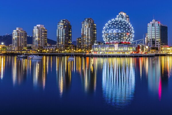 The lights of Vancouver at night are reflected in the water