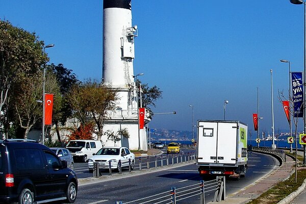 Strada con le auto sullo sfondo del faro