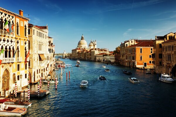 Foto de un río en Italia con barcos cerca de casas