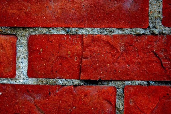 Ein Fragment einer leuchtend roten Backsteinmauer