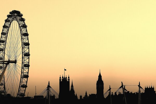 Siluetas de London Eye y Big Ben en el cielo amarillo