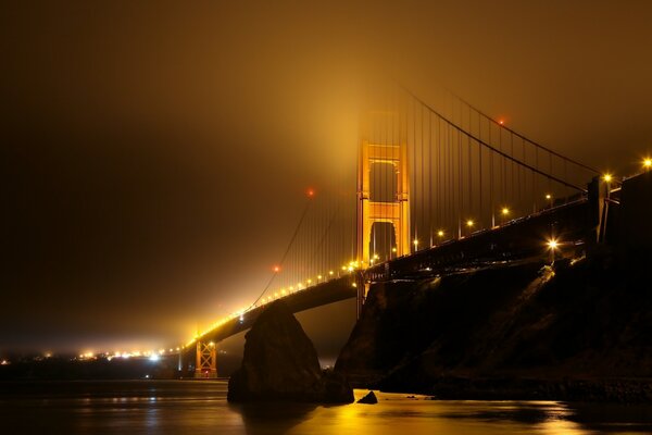 A glowing bridge in a foggy night