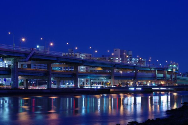 Luces de la ciudad nocturna en la orilla del río